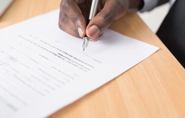 Hand unterschreibt Dokument